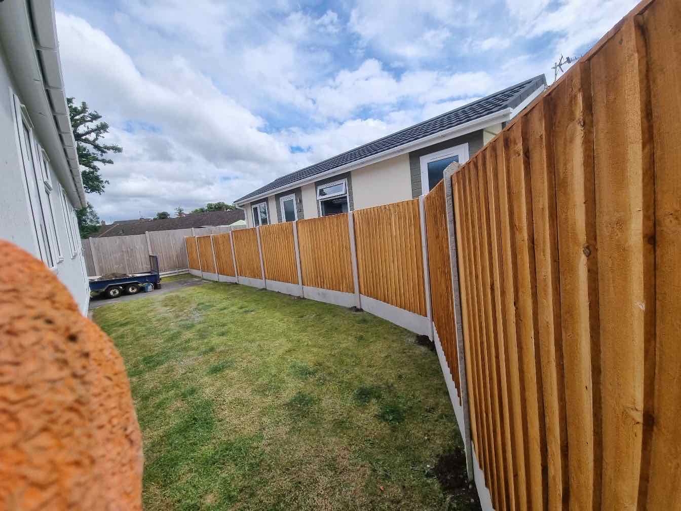 New closeboard fence panels on concrete posts along a bungalow garden boundary
