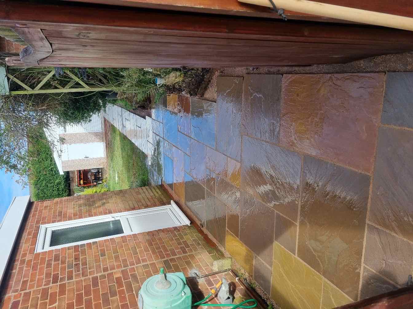 Indian sandstone patio and side passage being washed down after laying